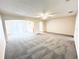 Large living room featuring neutral carpeting, abundant natural light, and a ceiling fan for added comfort at 4605 Ashburn Square Dr, Tampa, FL 33610