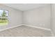 Bright bedroom with wood-look floors, neutral walls, baseboard trim, and a large window overlooking the yard at 4798 Jody Ave, North Port, FL 34288