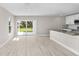 Bright living room with wood-look floors, a kitchen island, and sliding glass doors at 4798 Jody Ave, North Port, FL 34288