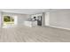 Open-concept living room featuring wood-look floors, neutral paint, and a kitchen island at 4798 Jody Ave, North Port, FL 34288