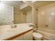 Bathroom with a sink, mirror, toilet and tiled shower and bathtub at 3703 43Rd W Ave, Bradenton, FL 34205