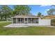 Charming home featuring a screened front porch, grey stone landscaping and ample sunlight at 7635 Pier Rd, Port Richey, FL 34668