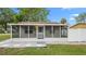 Charming home featuring a screened front porch, grey stone landscaping and ample sunlight at 7635 Pier Rd, Port Richey, FL 34668