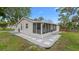 View of the rear of the home with a screened lanai and a stone pathway at 7635 Pier Rd, Port Richey, FL 34668