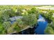 Stunning aerial view of home featuring a private dock, tranquil waterway, and lush landscaping, with mature trees at 5700 Oakview Ln, Punta Gorda, FL 33950