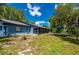 View of the backyard with a spacious lawn, patio, and view of the trees and sky at 5700 Oakview Ln, Punta Gorda, FL 33950
