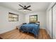 Cozy bedroom with hardwood floors, two windows offering natural light, and a ceiling fan for added comfort at 5700 Oakview Ln, Punta Gorda, FL 33950
