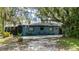 Charming home exterior features a large backyard patio and a well-maintained lawn with mature trees at 5700 Oakview Ln, Punta Gorda, FL 33950