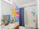 Bathroom with a colorful sun accent wall, shower-tub combo, and sink at 2647 Running Oak Ct, North Port, FL 34289