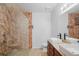 Bathroom showcasing double sinks, a granite countertop, and a glass-enclosed shower at 2647 Running Oak Ct, North Port, FL 34289