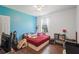 Bedroom with a red plaid bed, a blue accent wall, and a ceiling fan at 2647 Running Oak Ct, North Port, FL 34289