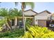 Charming home exterior with lush tropical landscaping and a welcoming front entrance at 2647 Running Oak Ct, North Port, FL 34289