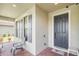Inviting front porch with brick flooring, stylish shutters, and a cozy chair, enhancing curb appeal at 2647 Running Oak Ct, North Port, FL 34289