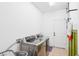 Laundry room with front-loading washer and dryer, utility sink, and white walls at 2647 Running Oak Ct, North Port, FL 34289