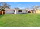 Well maintained backyard with green grass and a white house in the background at 8744 Candlewick Ln, Port Richey, FL 34668
