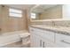 Bright bathroom with a granite countertop, white cabinets, and a tub at 8744 Candlewick Ln, Port Richey, FL 34668
