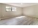 Bright bedroom featuring modern grey flooring and a window letting in natural light at 8744 Candlewick Ln, Port Richey, FL 34668