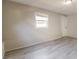 Bedroom with grey wood-look flooring, window, and a white back door at 8744 Candlewick Ln, Port Richey, FL 34668