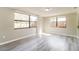 Bright living room featuring large windows and light gray laminate flooring at 8744 Candlewick Ln, Port Richey, FL 34668