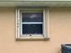 Exterior view of window with storm shutters, stucco and HVAC unit at 131 49Th E Ct, Palmetto, FL 34221