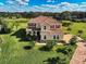 Aerial view of elegant estate home with tile roof, lush landscaping, and a serene pond at 7315 Bianco Duck Ct, Sarasota, FL 34240