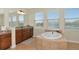 Bright bathroom featuring a large soaking tub, double vanity with granite counters and natural light from multiple windows at 7315 Bianco Duck Ct, Sarasota, FL 34240