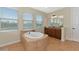 Bright bathroom featuring a large soaking tub, double vanity with granite counters and natural light from multiple windows at 7315 Bianco Duck Ct, Sarasota, FL 34240
