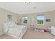 Bright bedroom with neutral walls, carpeted floor, and white furniture set. Natural light fills the space at 7315 Bianco Duck Ct, Sarasota, FL 34240