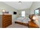Cozy bedroom with neutral walls, carpet, a mounted TV, and traditional wood furniture at 7315 Bianco Duck Ct, Sarasota, FL 34240