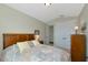 Bedroom featuring neutral walls, double doors, a wood headboard, and traditional furniture at 7315 Bianco Duck Ct, Sarasota, FL 34240