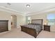 Large main bedroom with neutral carpet, tray ceiling, and windows with blinds at 7315 Bianco Duck Ct, Sarasota, FL 34240