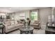 Comfortable living room with neutral tones, large windows, and an open layout at 11427 Pickford St, Spring Hill, FL 34609