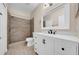 Bathroom with white vanity, framed mirror, and tile shower at 5857 Fishhawk Ridge Dr, Lithia, FL 33547