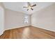 Light-filled bedroom featuring wood floors, ceiling fan, and a window at 5857 Fishhawk Ridge Dr, Lithia, FL 33547
