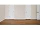 Bedroom showcasing wood-look floors and several white doors at 5857 Fishhawk Ridge Dr, Lithia, FL 33547