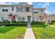 Inviting exterior of a townhome featuring a walkway, green lawn, and American flag at 5857 Fishhawk Ridge Dr, Lithia, FL 33547
