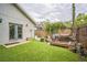 Backyard with a wooden deck, lush artificial grass, and a wooden privacy fence at 3610 N Tampa St, Tampa, FL 33603