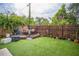 Backyard featuring a wooden deck, artificial grass, and a wooden privacy fence at 3610 N Tampa St, Tampa, FL 33603