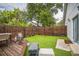 Backyard with a wooden deck, lush artificial grass, and a privacy fence at 3610 N Tampa St, Tampa, FL 33603