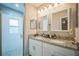 Bathroom featuring granite countertops, double sinks, modern fixtures, and a glass-enclosed shower at 3610 N Tampa St, Tampa, FL 33603