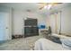 Bedroom features a large TV, desk, unmade bed, ceiling fan and wood-look tile flooring at 3610 N Tampa St, Tampa, FL 33603