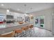 A bright kitchen with a granite countertop island with seating, stainless steel appliances, and access to backyard at 3610 N Tampa St, Tampa, FL 33603