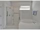 Large tub with stand up shower, window, and white tile at 8749 Ashworth Dr, Tampa, FL 33647