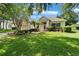 Charming home featuring a well-manicured lawn and lovely landscaping with mature trees and plants at 8749 Ashworth Dr, Tampa, FL 33647