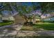 Inviting home exterior with lush green lawn, mature trees, and a well-maintained landscape at 8749 Ashworth Dr, Tampa, FL 33647