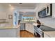 Open kitchen with stainless steel appliances, granite countertops, and a view to screened lanai at 8749 Ashworth Dr, Tampa, FL 33647