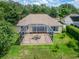 Aerial view of the patio with a screened in enclosure, patio furniture, and a well manicured yard at 8749 Ashworth Dr, Tampa, FL 33647