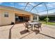 Covered, screened patio has brick flooring, outdoor dining set, and view of yard at 8749 Ashworth Dr, Tampa, FL 33647