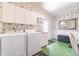 Clean laundry room with white appliances and green tile floor at 15200 Rawls Rd, Sarasota, FL 34240