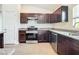 Modern kitchen with dark brown cabinets, granite countertops, and stainless steel appliances at 12128 Grouse Ave, Port Charlotte, FL 33981